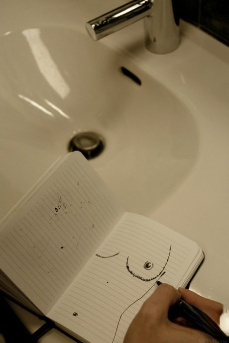 Young girl with a tight pussy gets totally naked while sketching in a notebook