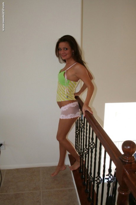 Sweet brunette babe Leslie B shows her hot ass and fake big tits