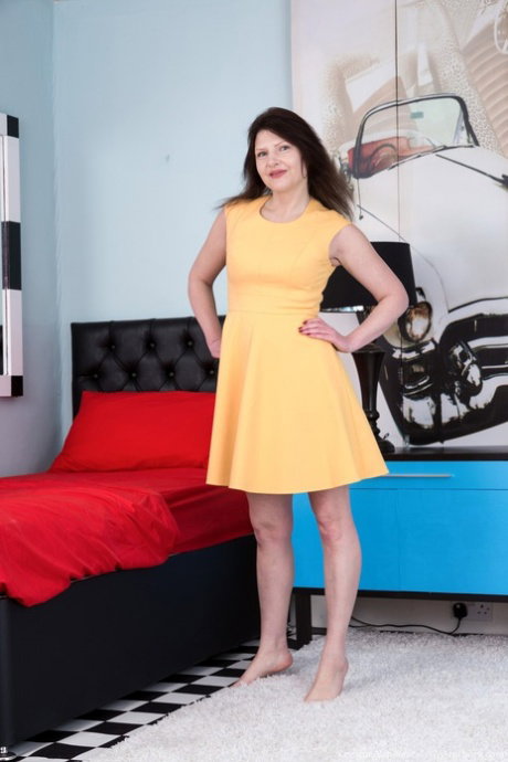 Brunette MILF Kristine Von Saar takes off her yellow dress and rubs her bush