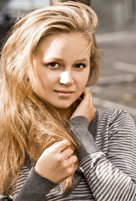 Young looking blonde Alexandra D creams her trimmed muff while posing naked