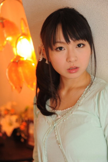Fully clothed Japanese girl Nozomi Hazuki holds her face firm in printed skirt