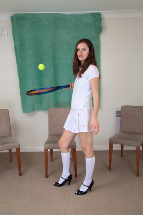 Brunette teen strips to white knee socks and heels while holding a racquet