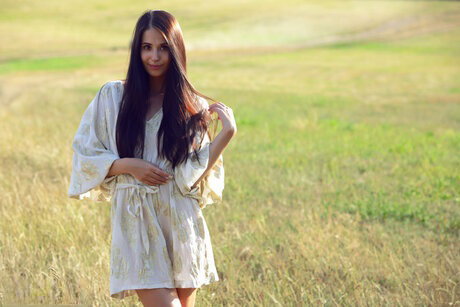 Young beauty Vanessa gets naked in a field before a close up of her pussy