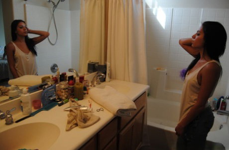 Long haired girl Kelly Xoxo puts her hair up while taking a shower