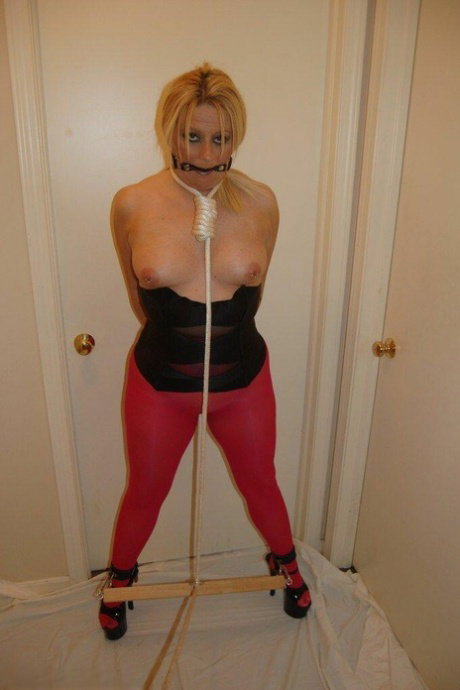 Blonde chick displays her boobs while ball gagged and restrained in pantyhose