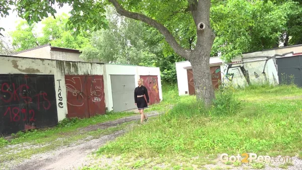 Blonde girl Nykla hitches up her dress before taking a piss by a garage  - Pissing, Pussy, Close Up, Panties, Shaved, Spreading, Outdoor, Skirt, Beautiful, Solo  - Photo 1