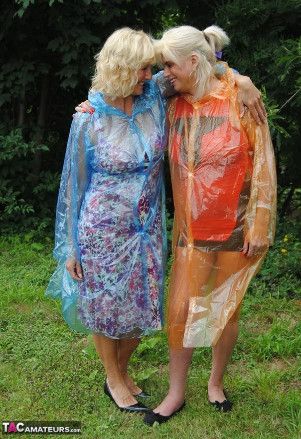 Mature lesbian Dimonty and GF cover their naked bodies in see thru raincoats  - Mature, Latex, Outdoor, Lesbian, Clothed, Skirt, Blonde, Humping, MILF, European  - Photo 1