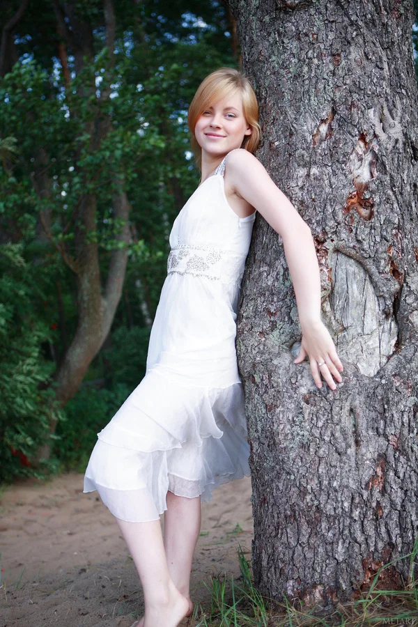 Pretty teen girl removes a white dress to get naked in a sunlit forest area  - Outdoor, Teen, Babe, Skinny, Beautiful, Cute, Model, Glamour, Skirt, Shaved  - Photo 1