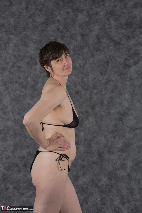 Short haired amateur holds her boobs after taking off a black bikini  - Saggy Tits, MILF, Short Hair, Bikini, Panties, Ass, Tiny Tits, Shaved, Legs, PAWG  - Photo 2