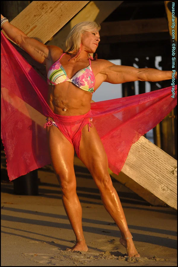 Blonde bodybuilder Lauren Powers flexes underneath a wharf in a bikini  - Beach, Bikini, Mature, Sports, MILF, Big Tits, Outdoor, Legs, Fake Tits, Blonde  - Photo 11