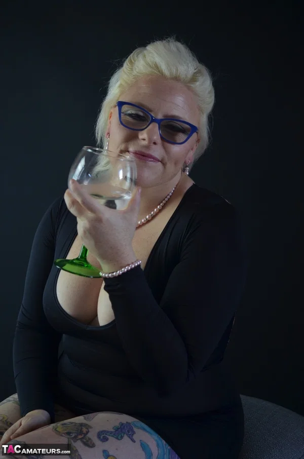 Tattooed blonde Mollie Foxxx prepares to swallow water from a goblet  - BBW, Mature, Chubby, Thick, Amateur, Tattoo, Curvy, Glasses, Clothed, Redhead  - Photo 1
