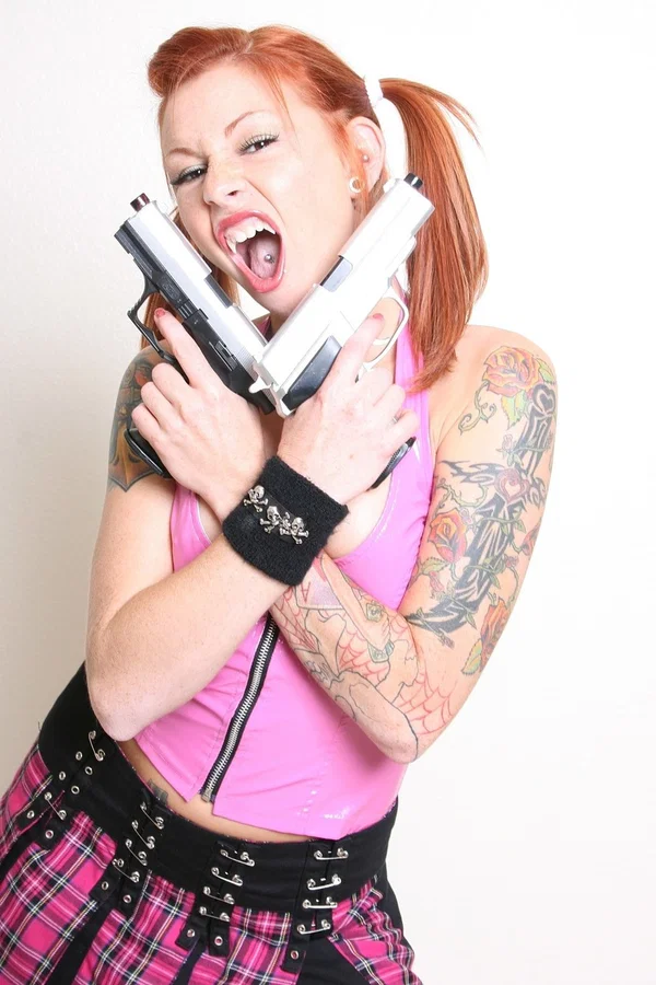 Amateur teen Scarlett exposes her pierced tits while posing with two guns  - Latex, Fetish, Skirt, Pigtails, Teen, Redhead, Tattoo, Socks, Tiny Tits, Amateur  - Photo 6