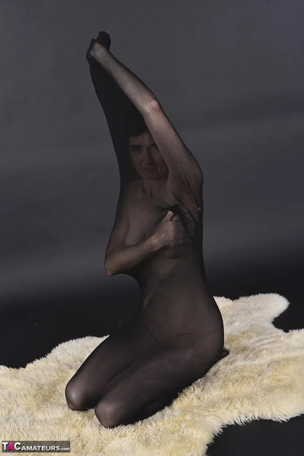 Naked mature woman encases herself in a stocking atop a rug  - Mature, Amateur, Saggy Tits, European  - Photo 9