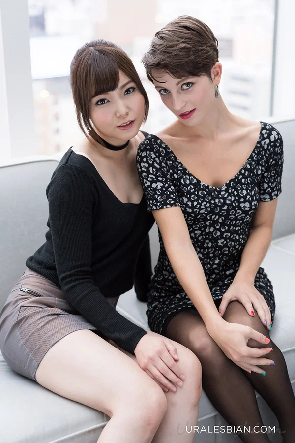 Interracial lesbian lovers help each other undress on a sofa  - Japanese, Asian, Lesbian, Stockings, Panties, Clothed, Brunette, Ass, High Heels, Lingerie  - Photo 1