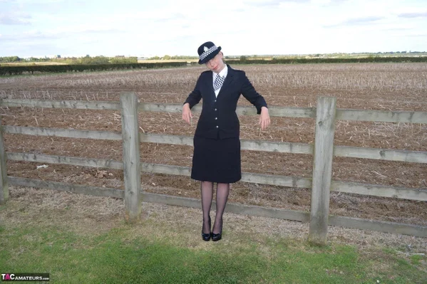 Mature policewoman Barby Slut removes her uniform against a fence at a farm  - Cosplay, Police, Mature, Outdoor, High Heels, Stockings, Lingerie, Big Tits, Uniform, Natural Tits  - Photo 1