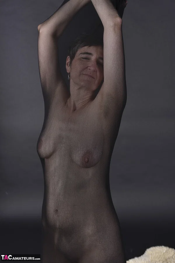 Naked mature woman encases herself in a stocking atop a rug  - Mature, Amateur, Saggy Tits, European  - Photo 5