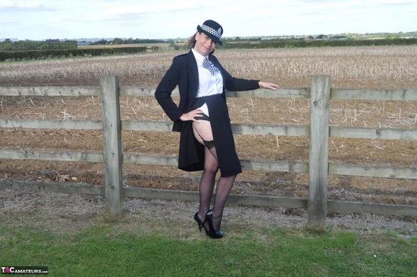 Mature policewoman Barby Slut removes her uniform against a fence at a farm  - Cosplay, Police, Mature, Outdoor, High Heels, Stockings, Lingerie, Big Tits, Uniform, Natural Tits  - Photo 6